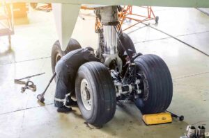 Repairing landing gear of the aircraft, technicians at work in the hangar.