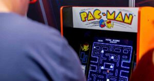 Kid playing Pac-man arcade game.